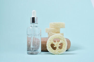 Cosmetic serum in white dropper bottles on natural stone. Blue background, natural skincare products concept.