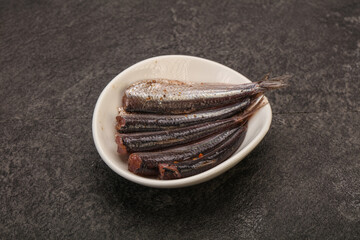 Anchovies in the bowl served basil leaves