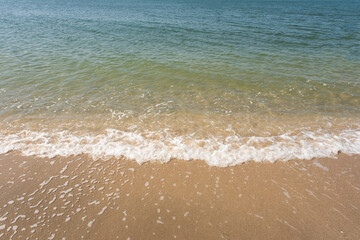 Soft ocean wave of blue ocean on tropical sandy beach in summer background with copy space. texture Background