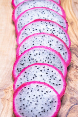 Fresh sliced white dragon fruit as background.