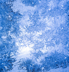 Fototapeta na wymiar blue texture of frost ice surface with frozen design tracery ,cold cryslallized surface background ,winter glass side close up , abstract macro wallpaper