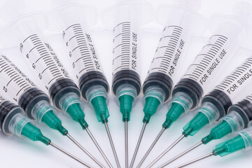 clear plastic syringes with needles isolated against a white background
