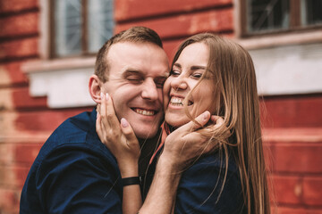 Fototapeta premium Happy couple hugging and smiling. Portrait of a guy and a girl with a smile on their faces.