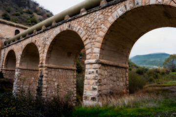 Fototapeta na wymiar Bridge to transport water in a town between mountains