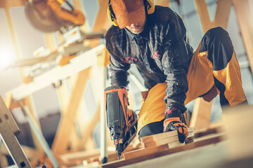 Construction Worker with Nail Gun in His Hand - obrazy, fototapety, plakaty