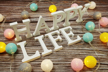 Happy Life alphabet letter with LED cotton balls on wooden background