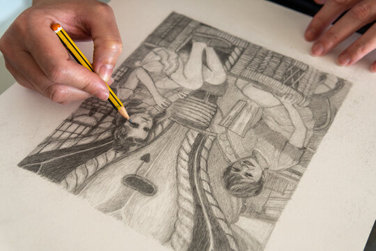 Close-up of hands making a figurative drawing in black and white