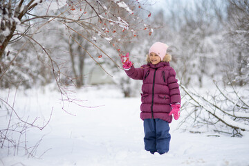 A child girl on a walk in a winter park