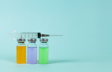 Covid-19 Recorded vaccine bottle with liquid and and syringe on a blue background. Place for text