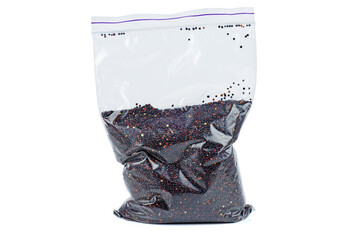 Raw black quinoa seeds in plastic packet isolated on a white background