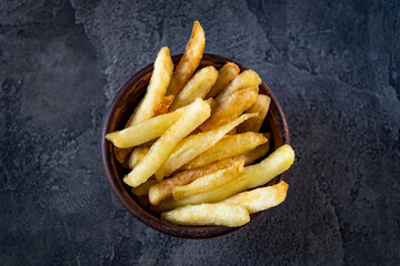 Bowl filled with crispy french fries on table