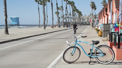 Blue bicycle, cruiser bike by sandy ocean beach, pacific coast near Oceanside pier, California USA....