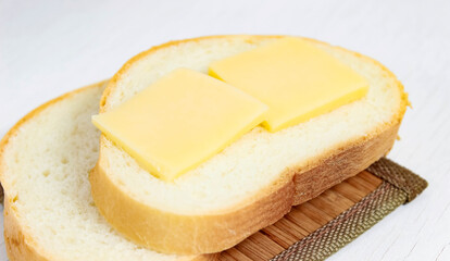White bread with sliced hard cheese. A grilled cheese sandwich.