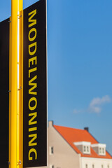 Realtor sign with the Dutch text "show house" in front of a newly built family house