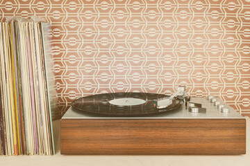 Vintage record player with record albums in front of seventies wallpaper - 409877679