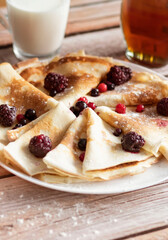 
Homemade pancakes, delicious thin pancakes with berries and maple syrup