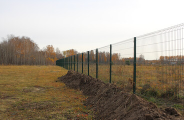 fenced territory behind a metal fence the land plot is closed