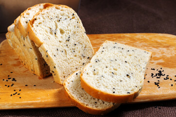 Black sesame bread freshly baked homemade is placed on a wooden cutting board and cut into equal strips. Good to eat for health.