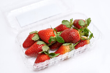 fresh strawberries in a container on a white background