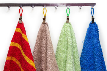 Colored terry towels hanging on the hanger hooks, fragment
