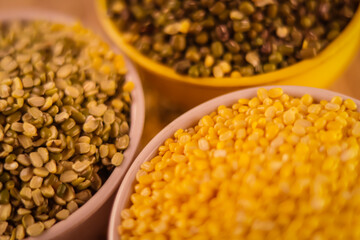 Plastic bowl and wooden spoon with Raw mung beans and moong dal rotation,Mung bean, green moong dal with wooden spoon,