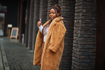 Glamorous african american woman in warm fur coat pose at street.