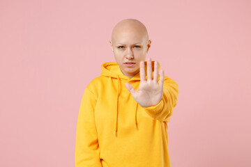 Young bald caucasian troubled strict serious woman 20s without hair wearing yellow casual...