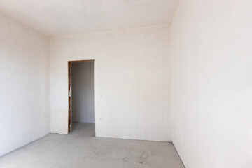 New empty room under construction. Plaster walls. New home. Concrete walls. Interior renovation.