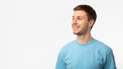 Fototapeta premium Smiling confident guy looking at copy space on white background