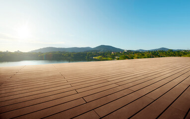 Empty wooden floor in front of.lake view background during sunrise.