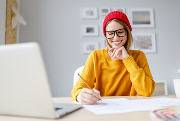 Happy young woman sketching during work