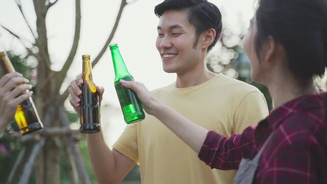 Friend clinking and drinking bottles of beer with happiness and smile.