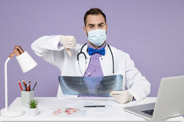 Male doctor man wearing medical gown sterile face mask latex gloves hold X-ray of lungs...