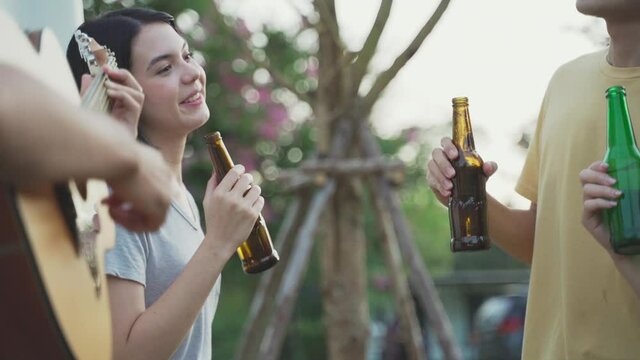 Friend clinking and drinking bottles of beer with happiness and smile.