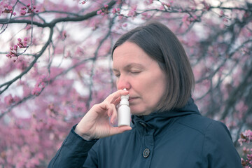 Woman using nasal spray outdoors