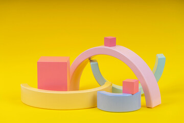 Wooden geometric shapes forms colorful figures composition on yellow background