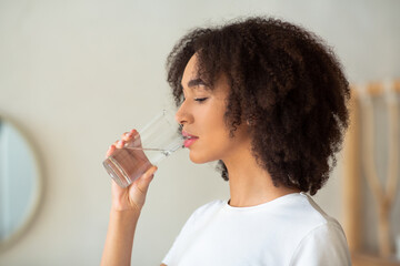 Thirsty woman holds glass drinks still water preventing dehydration
