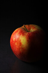 An apple against black background