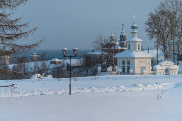 Panoramic view of the ancient city of Cherdyn (Northern Ural Russia), located on several hills. Historic center with beautiful wooden churches, houses, trees and deep snow on a winter day 