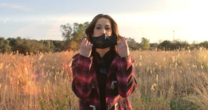 Ragazza si toglie la mascherina e respira aria pura in campagna