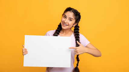 Indian woman pointing at blank white advertising board