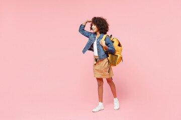 Full length happy little african american kid school girl 12-13 year old in casual clothes, backpack hand at forehead look far away distance isolated on pink background. Childhood education concept