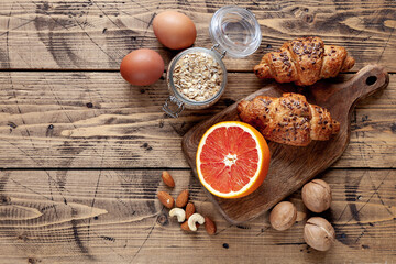 Organic food background with grapefruit, cereal, eggs and nuts, top view