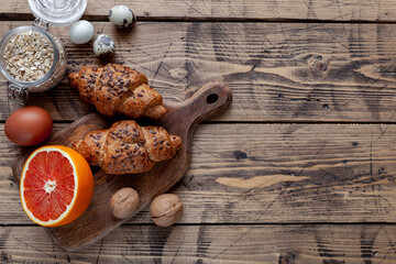 Grapefruit, bakery, nuts, eggs on wooden table, top view