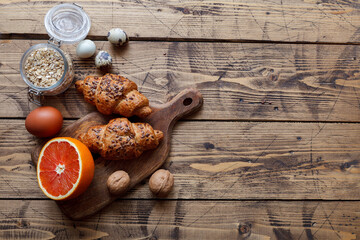 Healthy organic food: grapefruit, eggs, nuts on wood texture, top view
