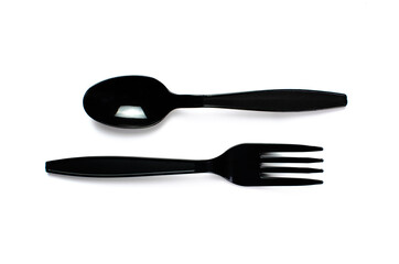 Black plastic cutlery knife fork spoon isolated on white background low highlight. For kitchen restaurant and table set up. concern to plastic conservative recycle items and one time use utensils