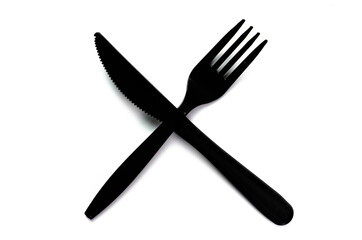 Black plastic cutlery knife fork spoon isolated on white background low highlight. For kitchen restaurant and table set up. concern to plastic conservative recycle items and one time use utensils