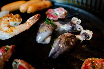 Grilled shrimp and seafood on tradition charcoal grill stove. Japanese Barbecue mixed with seafood bbq. Original asian heat plate. 