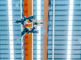 Overhead crane and machine inside factory building, industrial background.
