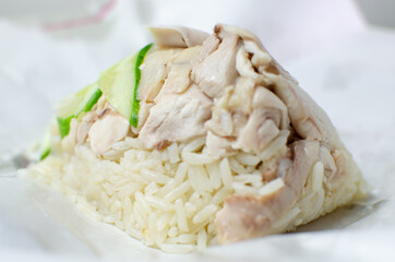 Thai chicken rice in tradition paper wraps with chickens skin and cucumber and sauce
